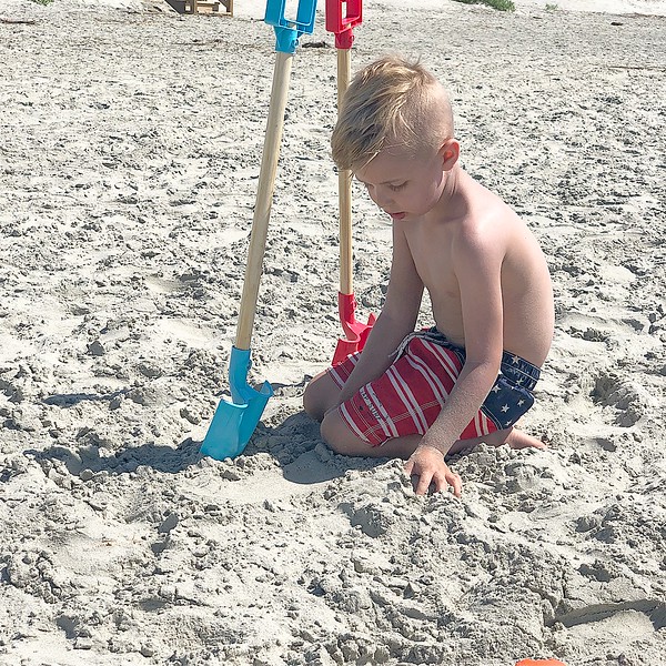 Family enjoying a summer backyard BBQ with outdoor dining and grill in Charleston.