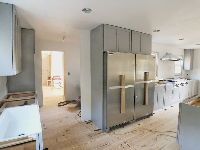 Charleston kitchen renovation progress showing cabinets installed and flooring underway.