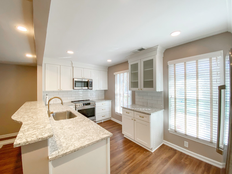 Before and after of a townhouse kitchen renovation showing modern cabinets, countertops, and fresh design updates.