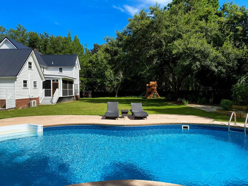 Family enjoying a summer backyard BBQ with outdoor dining and grill in Charleston.