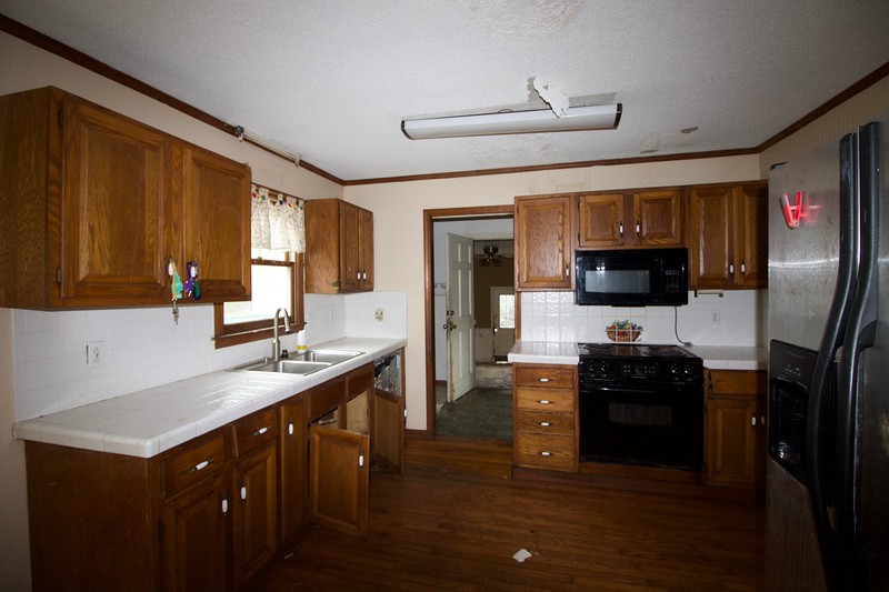 Before photos of a foreclosure home with a pool and spacious yard ready for renovation.