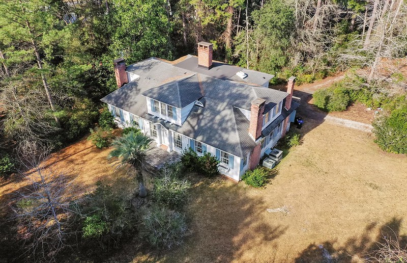 Historic 1930 Charleston home surrounded by trees on a private 2.5-acre lot.